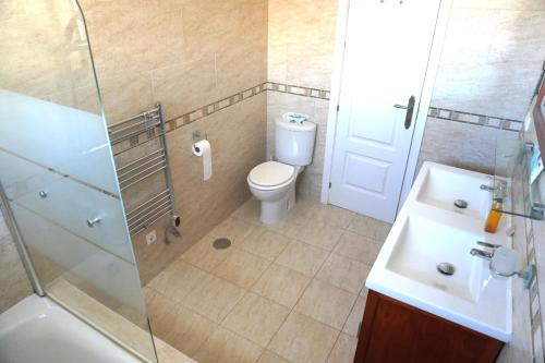 y baño con aseo, lavabo y ducha. en Villa Seaview Suncoast Luxury, en Málaga
