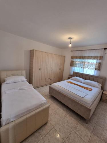 a bedroom with two beds and a window at Zani GuestHouse in Fier