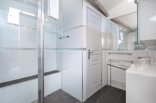 une salle de bain avec douche et porte vitrée dans l'établissement Suite Notre Dame - Appartements, à Cannes