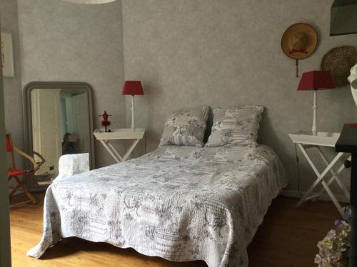 een slaapkamer met een bed, 2 tafels en een spiegel bij Villa des sables in Duinkerke