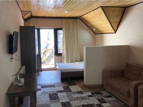 a living room with a couch and a bed at ECOHOTEL ''QIZIL Dere'' 