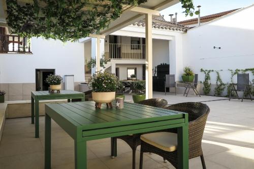 a green table and chairs in a patio at Tomé, casa de huéspedes in Orgaz