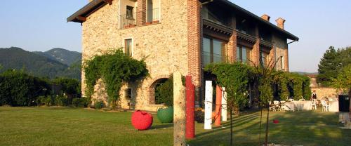 a building with vases in the grass in front of it at B&B Il Posto delle Rose in Almenno San Salvatore