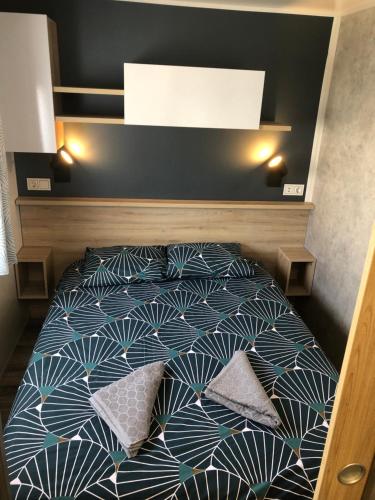 una cama con almohadas en una habitación en Mobile Home de standing, en Canet-en-Roussillon