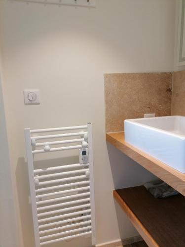 La salle de bains est pourvue d'un lavabo et d'un lavabo blancs. dans l'établissement A GAUGUIN Cyclistes Ventoux, à Malaucène