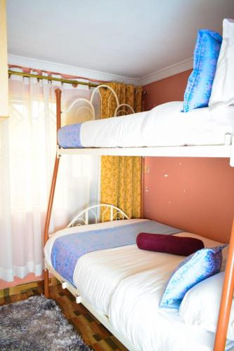 a bedroom with two bunk beds and a window at Cozy 2 bedroom in a family home in Nakuru