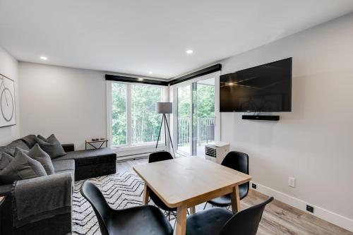 a living room with a couch and a table at Le PanoramiK by Gestion ELITE in Mont-Tremblant