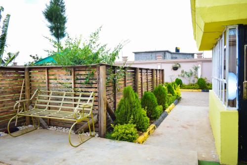a bench in a garden next to a fence at Cozy 2 bedroom in a family home in Nakuru