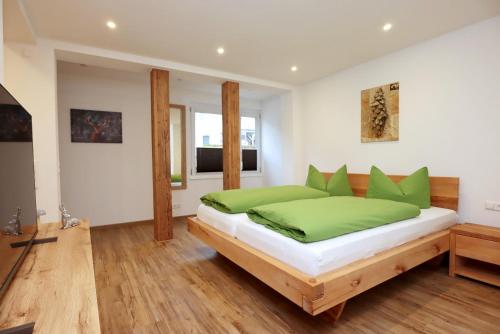 a bedroom with a bed with green pillows at Ferienwohnungen Rebstock in Schonach