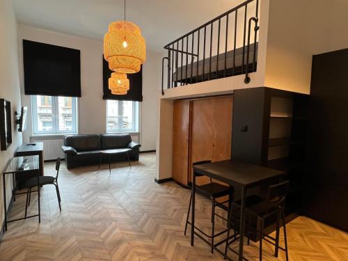 ein Wohnzimmer mit einem Tisch, Stühlen und einem Sofa in der Unterkunft I&M Apartments Rejtana Wrocław in Breslau