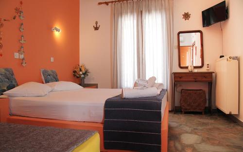 a hotel room with a bed and a mirror at Helios Serifos in Livadi