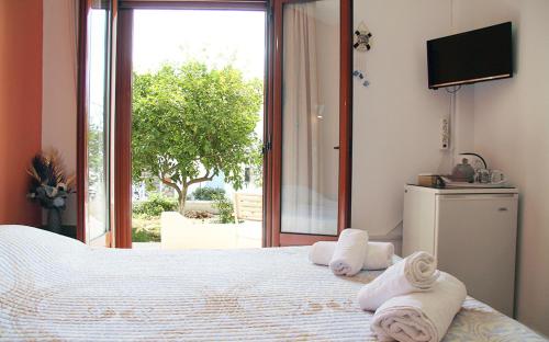 a bedroom with a large bed with towels on it at Helios Serifos in Livadion