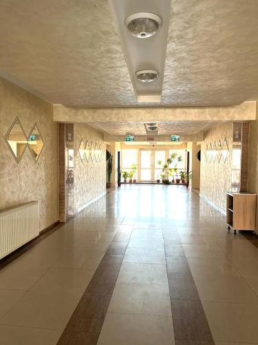een grote lobby met een grote tegelvloer in een gebouw bij Eden Guest Aparthotel, Oradea, Romania in Oradea