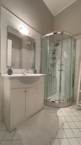 a white bathroom with a shower and a sink at Chez Papa Appartamenti - Chez Coco in Ravenna
