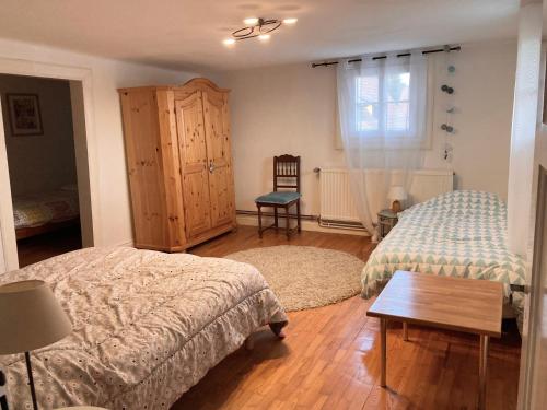 um quarto com 2 camas e piso em madeira em Maison Alsacienne Typique Gite Weiss em Gunstett