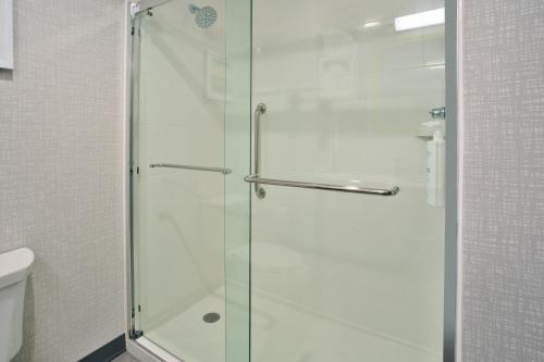 um chuveiro com uma porta de vidro na casa de banho em Hampton Inn Paris, Tn em Paris