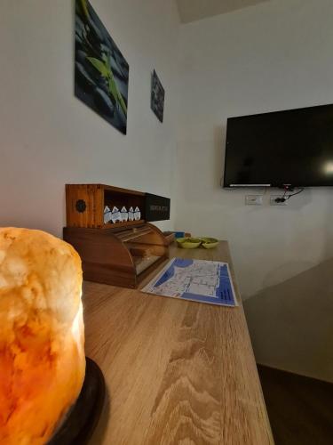 a living room with a wooden table and a television at Ai Due Cortili in Trapani
