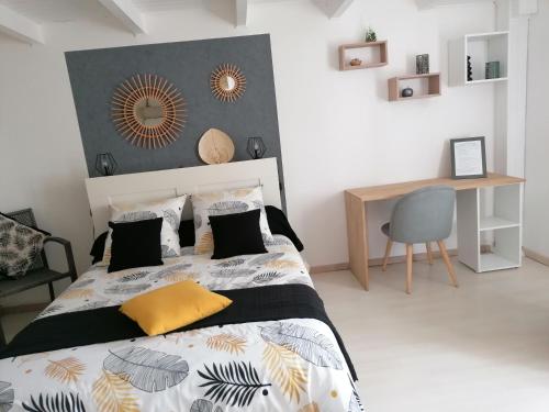 een slaapkamer met een bed en een bureau erin bij Le Cottage in Rochefort