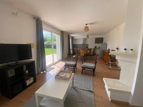 a living room with a television and a table and chairs at Maison des Grands Champs in Saint-Aignan