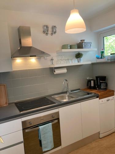 een keuken met een wastafel en een fornuis top oven bij Balance Apartments by M&A - City Apartment Witzenhausen in Witzenhausen