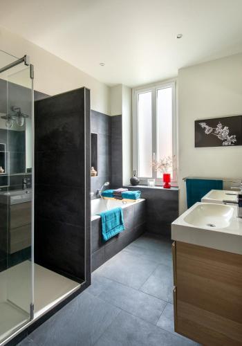 a bathroom with a shower and a sink and a tub at La Maison Vague - Guest House in Marseille
