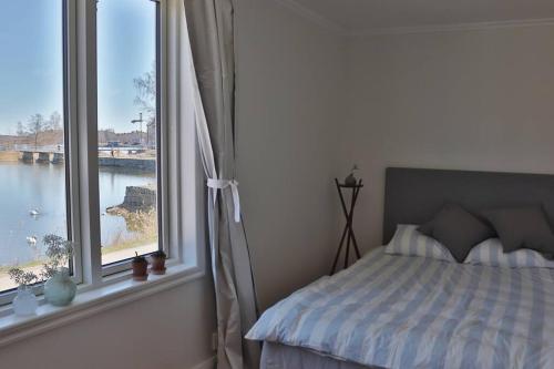 a bedroom with a bed and a large window at Captivating Harbor View Suite in Östhammar