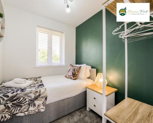 a bedroom with a bed and a green wall at LOW Price this winter 3 Bedroom House in Coventry - Sleeps 5 - With Free Unlimited Wi-fi, Driveway & Garden By Passionfruit Properties- 26WWC in Coventry