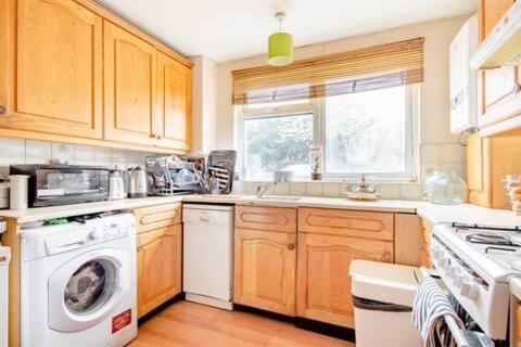 a kitchen with a washing machine and a washer at Lovely and comfortable Home Stay in London in London