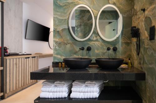 a bathroom with two sinks and two mirrors at Lagomandra Beach Hotel in Lagomandra