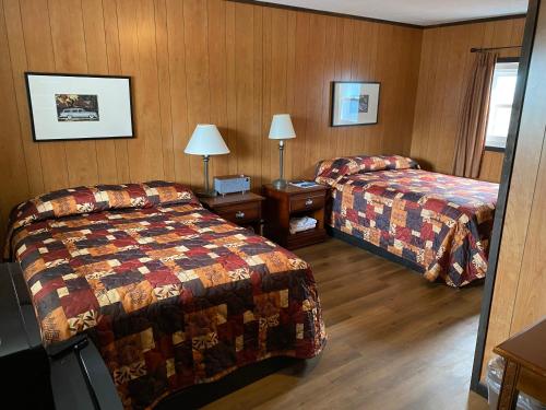 een hotelkamer met 2 bedden en een spiegel bij Scotty's Motel in Munising