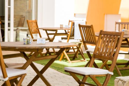 a group of wooden tables and chairs on a patio at Casa Amarela Guesthouse in Albufeira