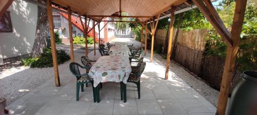 a table and chairs sitting under a gazebo at Timbi Vendégház in Vonyarcvashegy