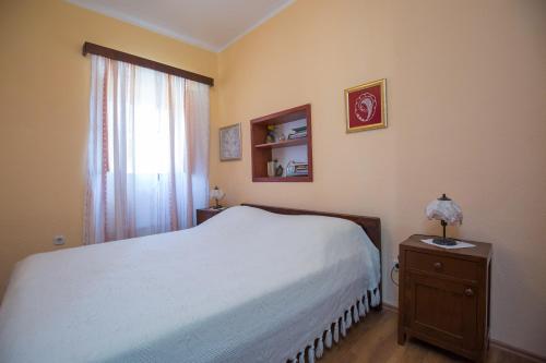 a bedroom with a white bed and a window at Visilo Stone House in Pučišća