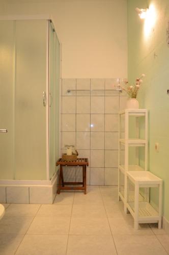 a bathroom with a shower and a table and a stool at Visilo Stone House in Pučišća