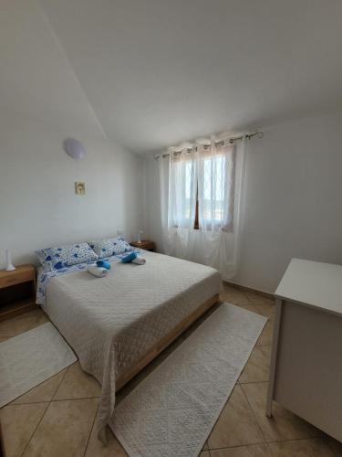 una camera da letto con un letto con cuscini blu e una finestra di Casa Clara a Bari Sardo