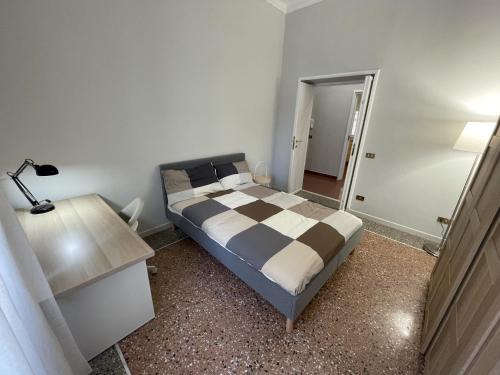 um quarto com uma cama e uma secretária com um candeeiro em Piazza Vescovio Apartment em Roma