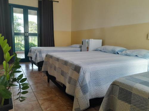 1 dormitorio con 2 camas y nevera en HOTEL NOVO HOTEL, en Três Lagoas