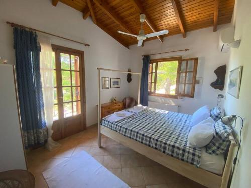 Jenny's Guesthouse! في أرتيميدا: غرفة نوم مع سرير في غرفة مع نوافذ