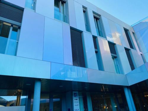 an office building with blue glass panels on the side at Blue Shades Hotel in Pisa
