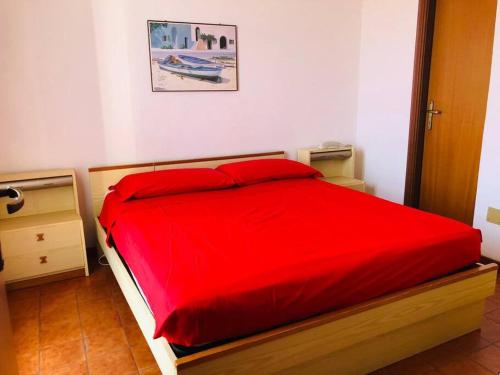 Un dormitorio con una gran cama roja con almohadas rojas en Pietra Ligure - Essential with Swimming Pool, en Pietra Ligure
