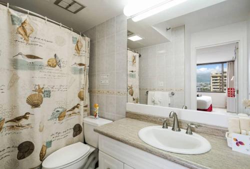 a bathroom with a toilet and a sink and a mirror at Maluhia Mountain View Suite 1 bed 1 Free Parking in Honolulu