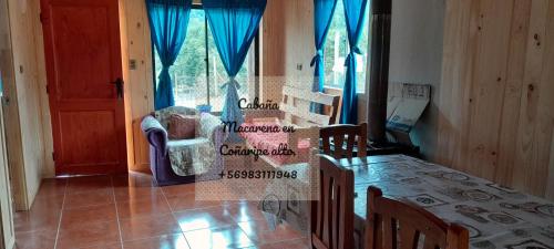 a dining room with a table and chairs and a window at Cabañas,Buena vista. in Coñaripe