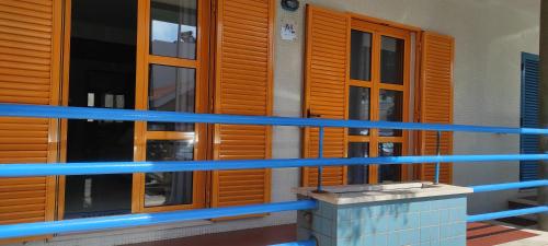 a building with wooden doors and a blue railing at Vista do Farol in Gafanha da Nazaré