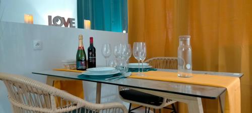 uma mesa de jantar com copos de vinho e garrafas de vinho em Sixième Sens - 1828 