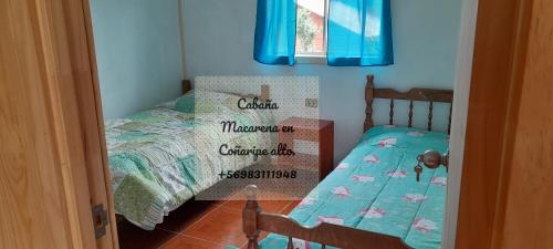 sypialnia z 2 łóżkami pojedynczymi i łóżeczkiem dziecięcym w obiekcie Cabañas,Buena vista. w mieście Coñaripe