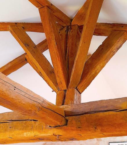 a wooden ceiling with wooden beams on a ceiling at Linden Lodge Stays in Saint-Claud