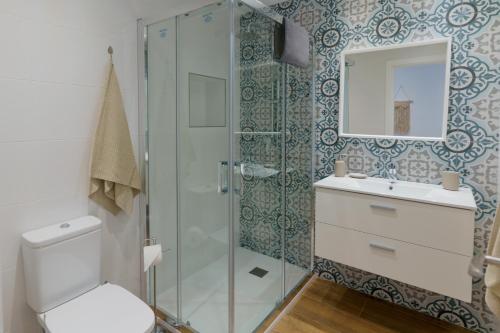 uma casa de banho com um chuveiro, um WC e um lavatório. em Casa Bluebelle Guadalmina em Marbella