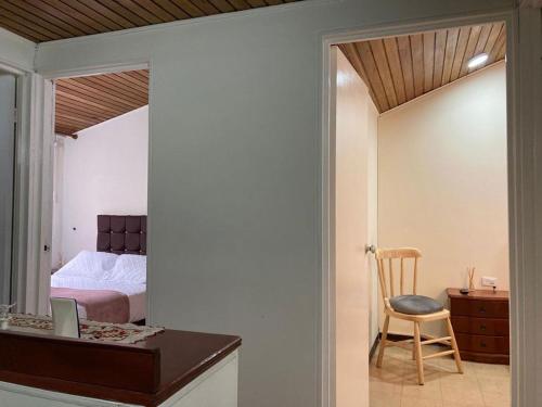um quarto com uma cama, uma secretária e uma cadeira em Como en casa em Bogotá