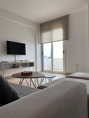 a living room with a couch and a tv at Dora's apartment in Dhërmi
