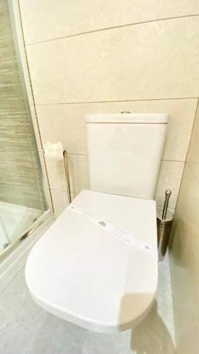 a white toilet in a bathroom with a shower at Casa Amarela Guesthouse in Albufeira